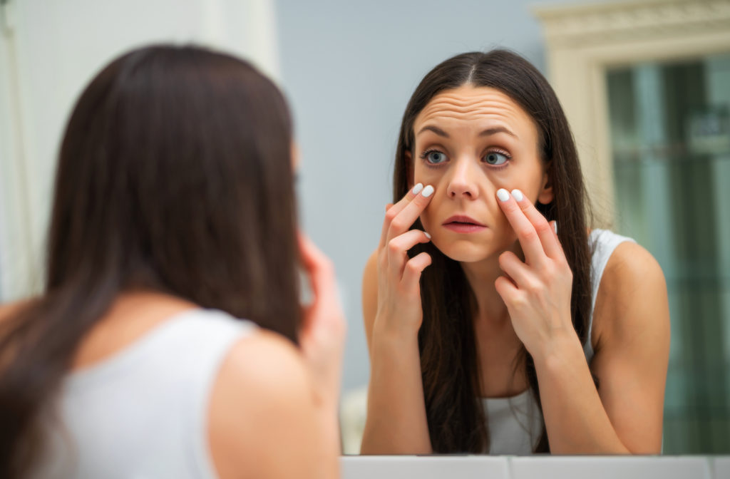 Women looking in mirror due to tired and dry eye