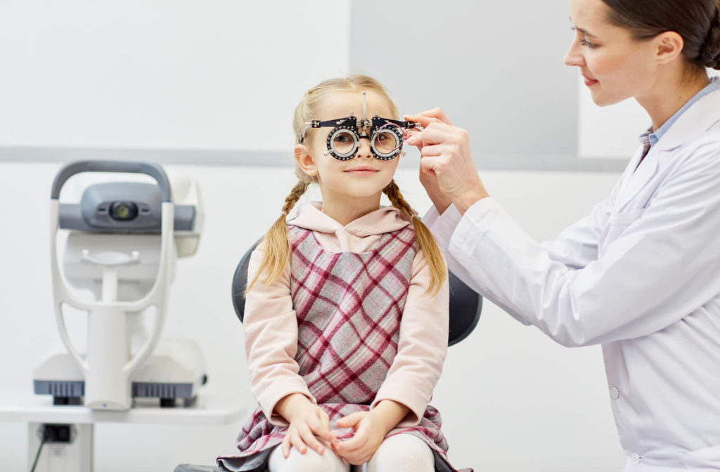 an optometrist performs a vision test on a young child