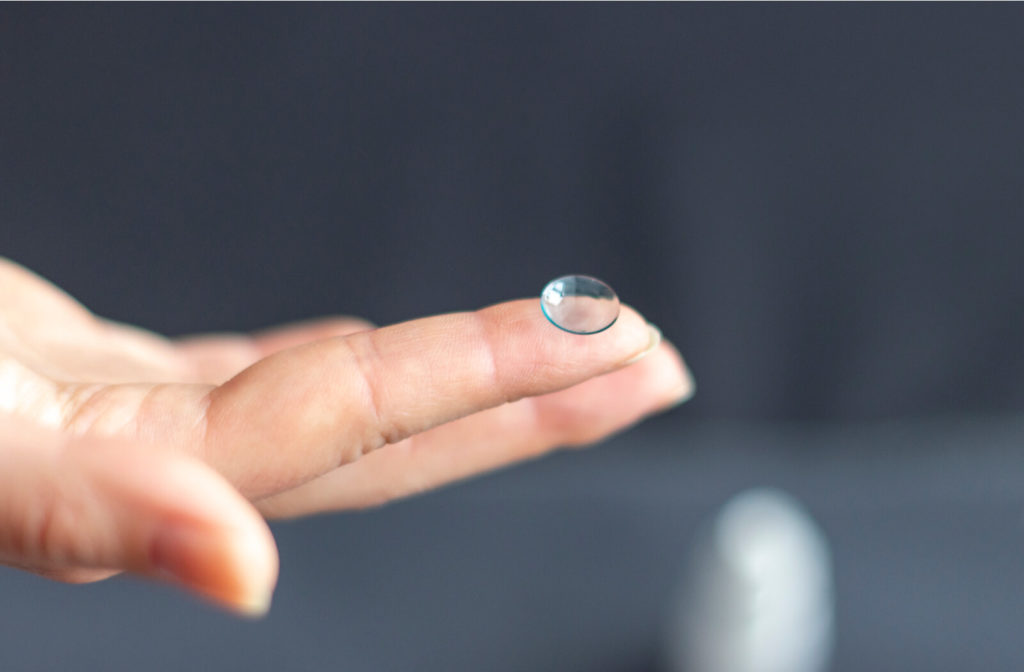 a hand holds an ortho-k contact lens
