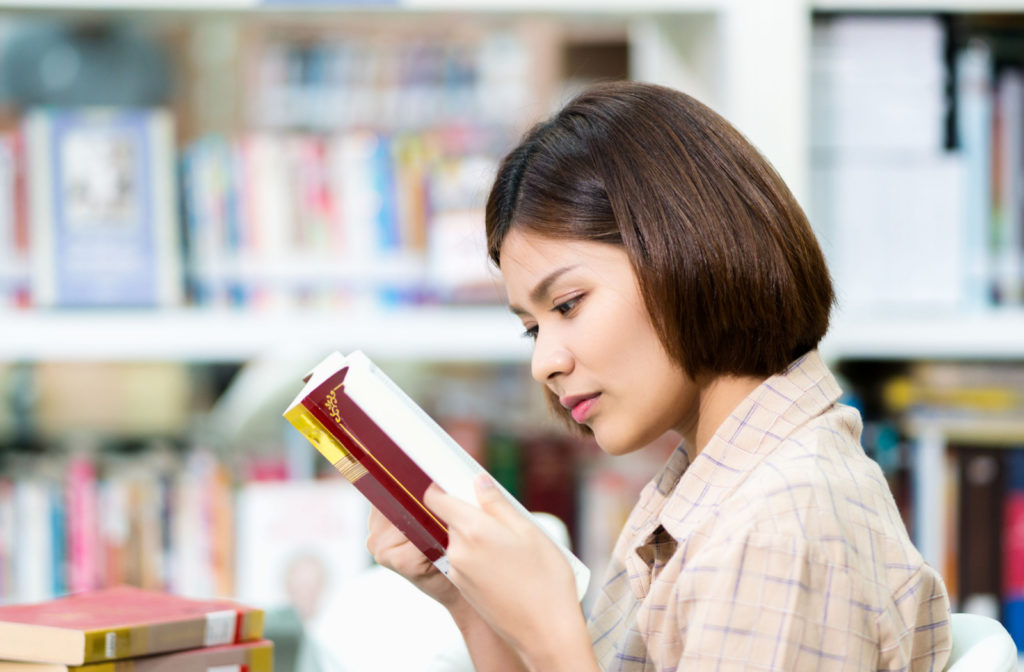 A lady reading a book close to her face has a possible progressing myopia.