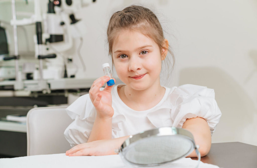 A young girl is holding a case with orthokeratological contact lenses. a modern method of correction of myopia.