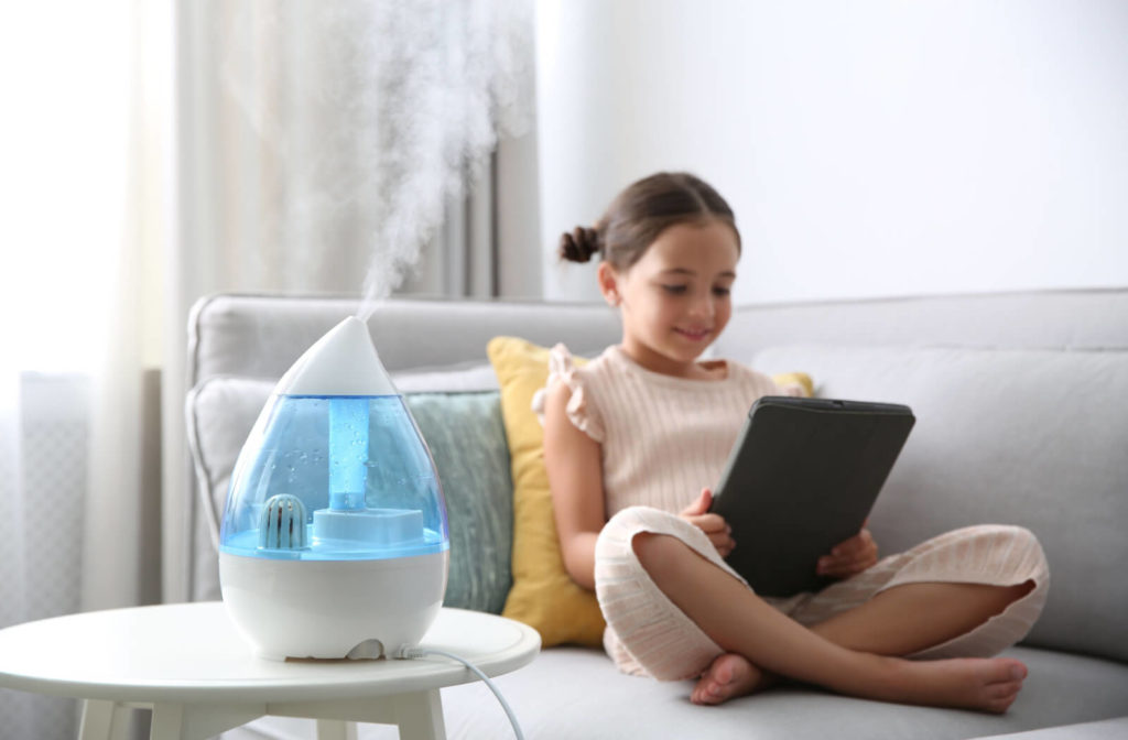 Young girl using a tablet near a humidifier to prevent eye damage