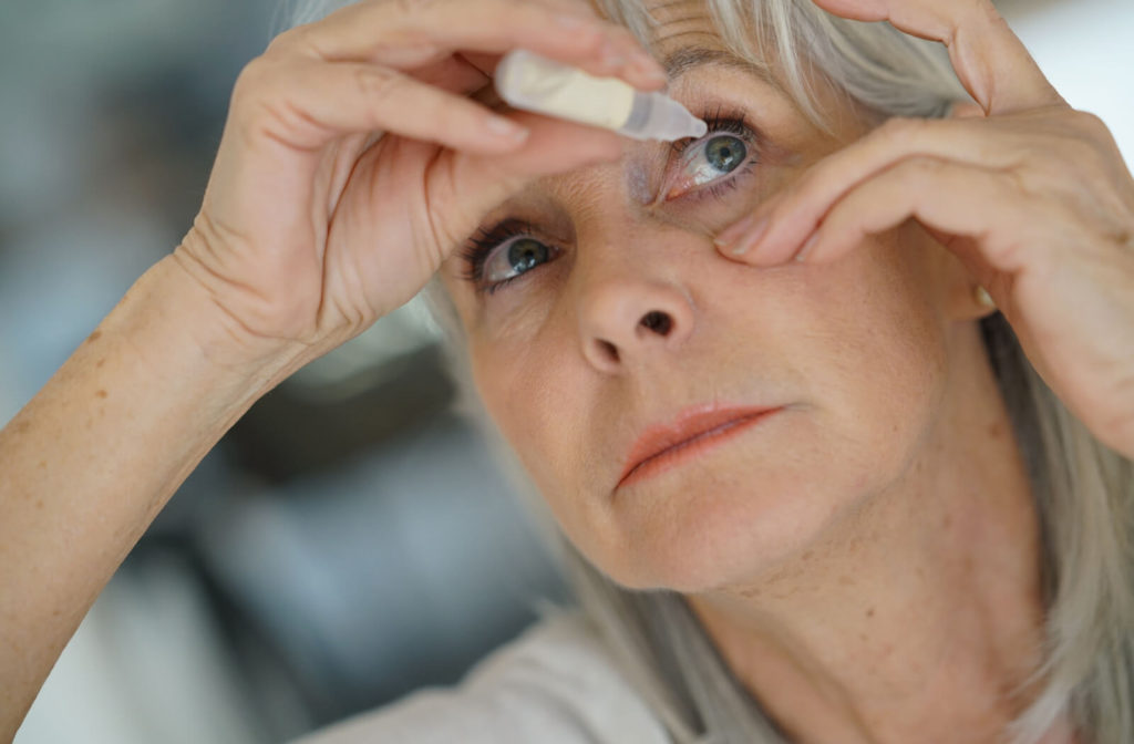 Senior woman using eyedrops to help keep her eyes hydrated.