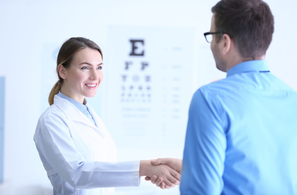 A man in an optometry clinic shaking hands with his female optometrist.