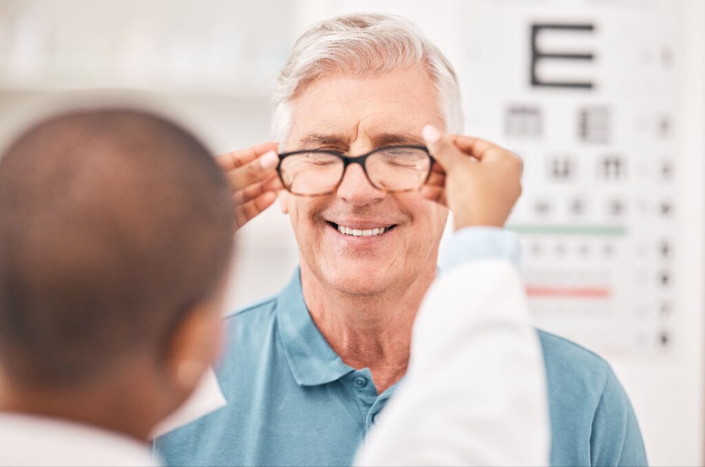 A smiling male patient being fitted with a pair of Neurolens glasses.