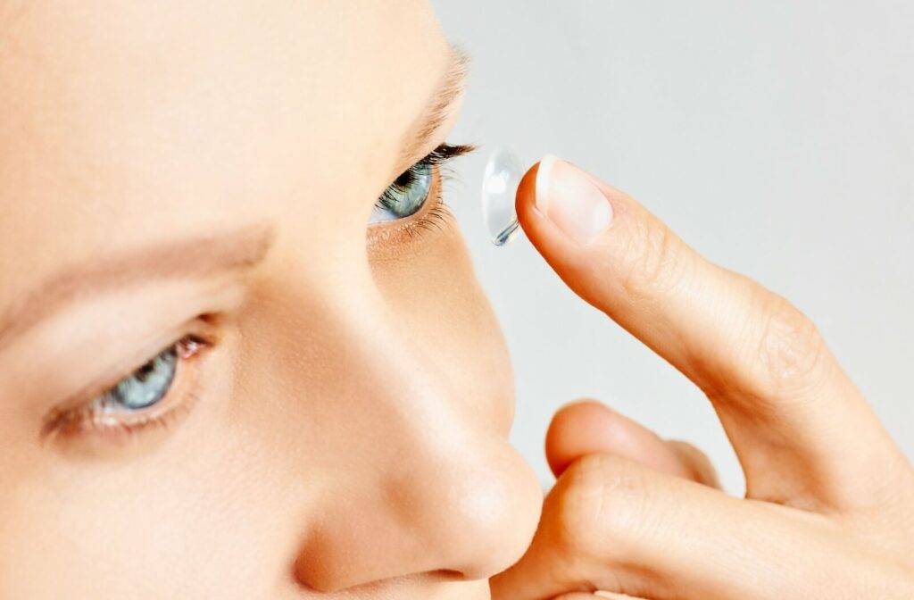 A person uses their finger to place a prescription contact lens into their eye to help control their myopia.