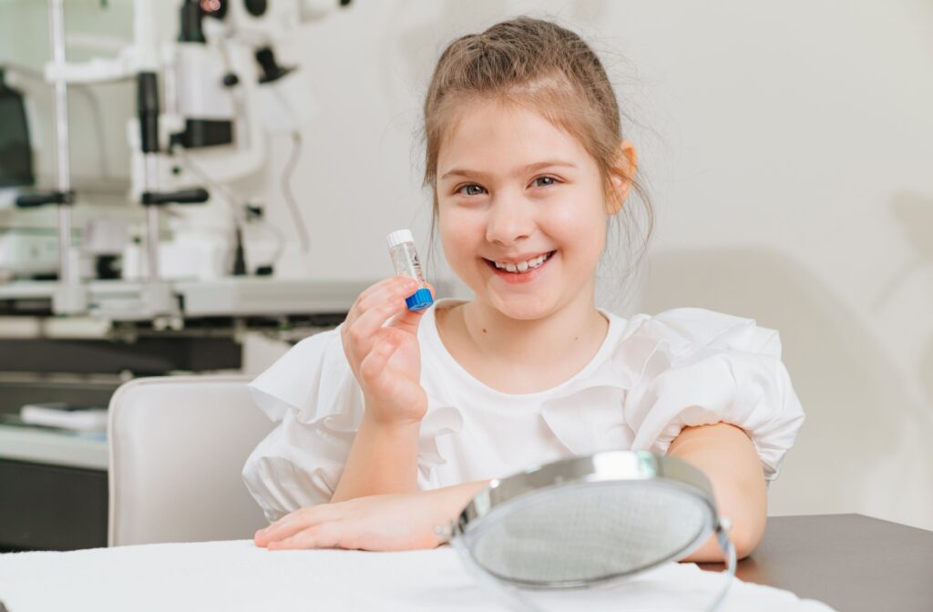 A young patient happily holding their ortho-k lenses in their storage container.