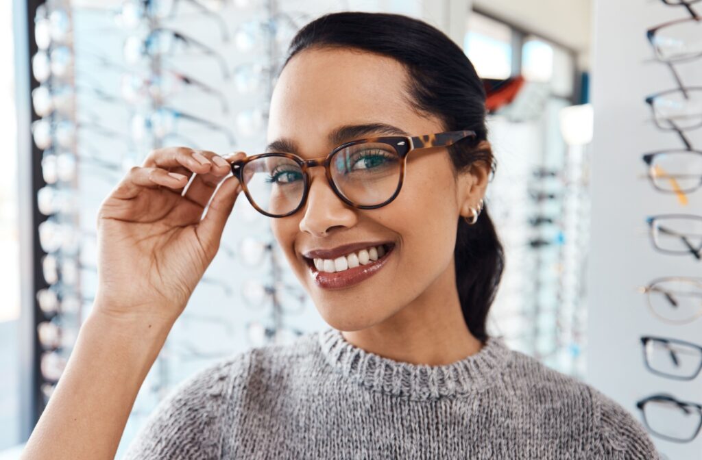 A person at an optometrist shows off their stylish custom glasses.