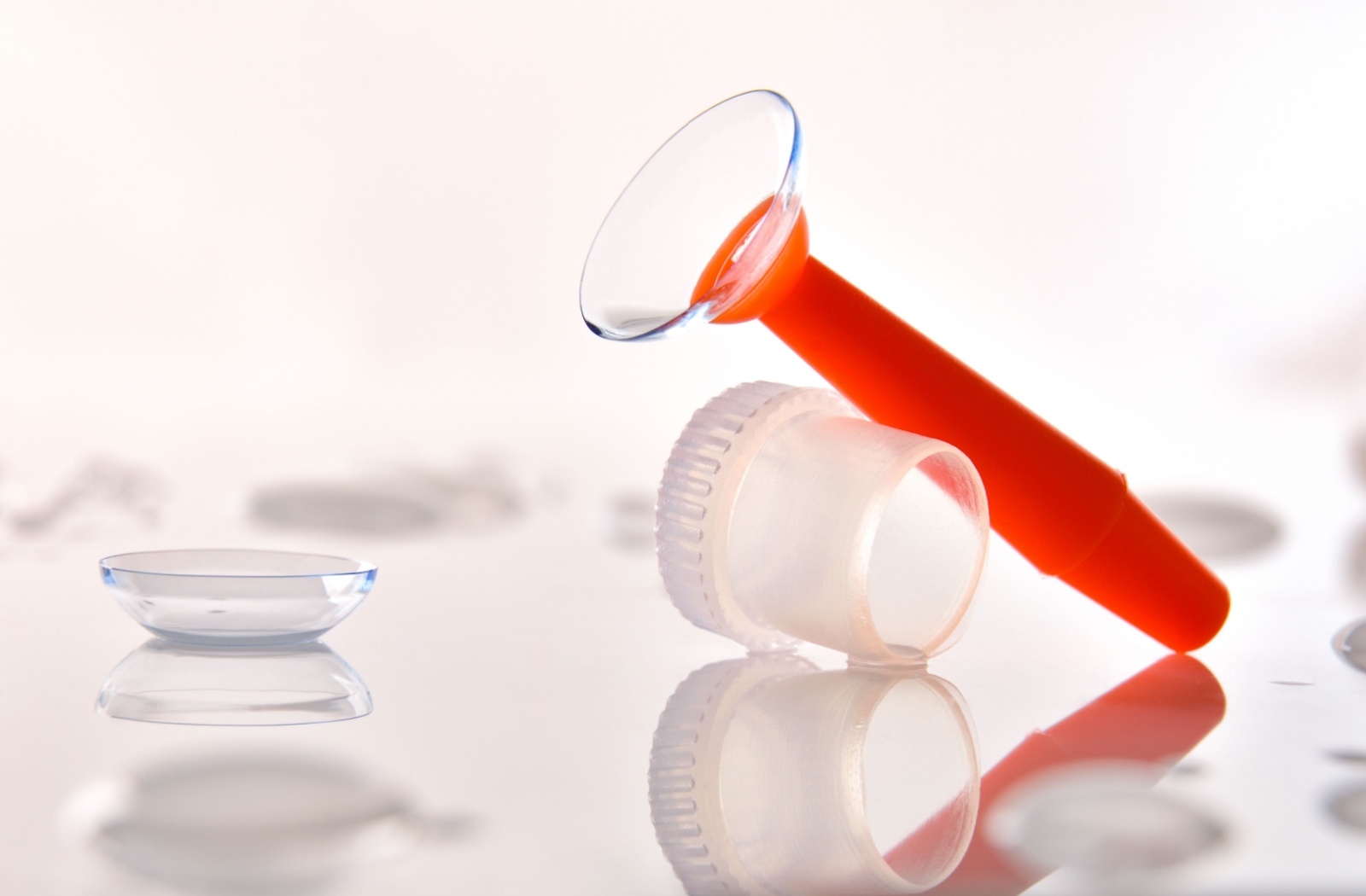 An orange suction tool holds a scleral contact lens.