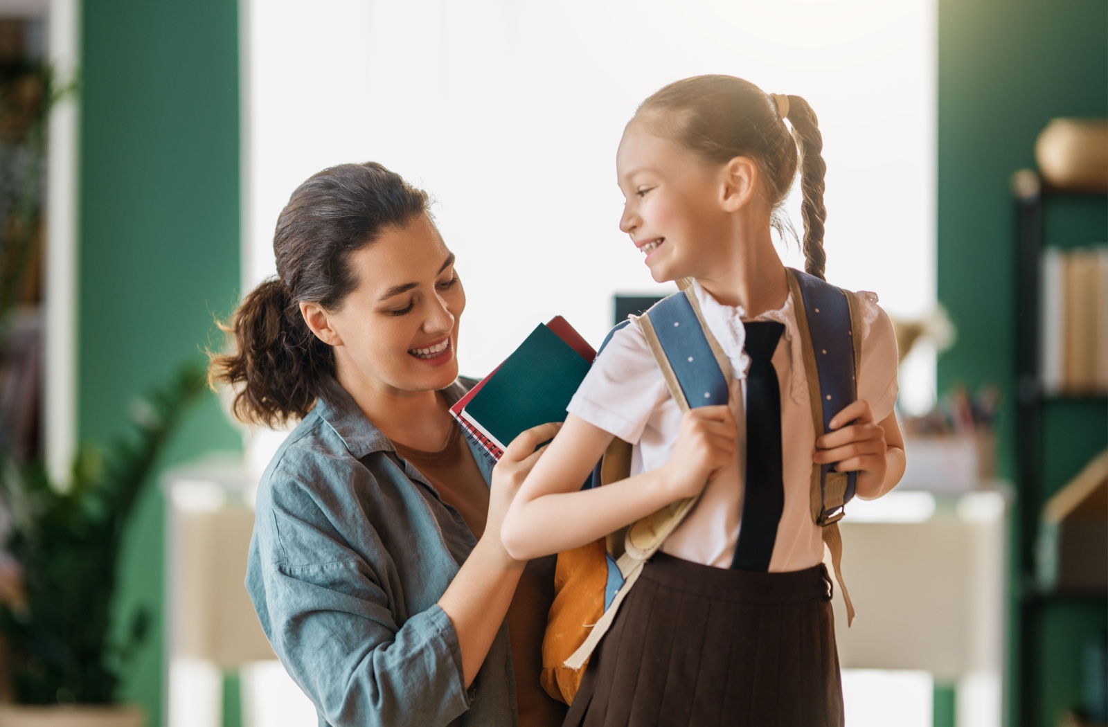 A parent helps their child get ready for their first day back to school.
